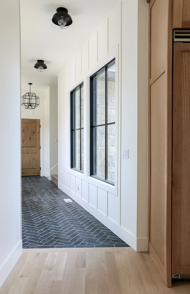 light hardwood floors black herringbone tile hallway black framed windows shiplap wall accent black industrial light fixtures hanging black pendant lantern